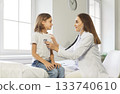 Pediatrician Using Stethoscope To Examine Schoolboy's Lungs In Hospital 133740610