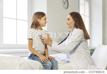 Pediatrician Using Stethoscope To Examine Schoolboy's Lungs In Hospital 133740610
