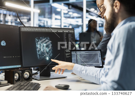 Data center engineering team monitoring system performance using PC, identifying bottlenecks. Server farm teamworking colleagues troubleshooting glitches, implementing optimizations Data center engineering team monitoring system performance using PC, identifying bottlenecks. Server farm teamworking colleagues troubleshooting glitches, implementing optimizations 133740627