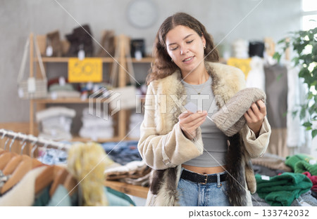Young woman choosing hat in clothing store Young woman choosing hat in clothing store 133742032