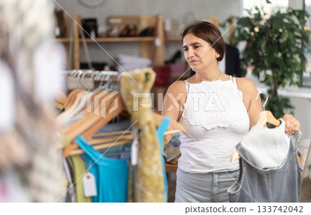 Latin woman customer turn over and choose something summer cloth in store, Latin woman customer turn over and choose something summer cloth in store, 133742042