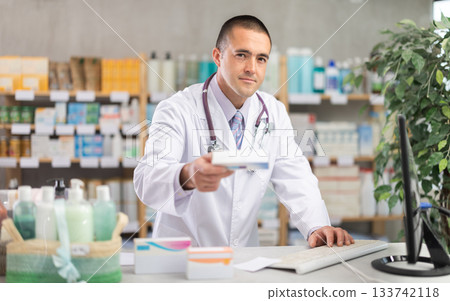 Man pharmacy employee works with computer Man pharmacy employee works with computer 133742118