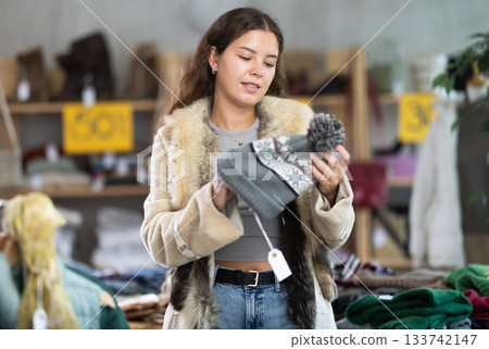 Young girl choosing hat in clothing store Young girl choosing hat in clothing store 133742147