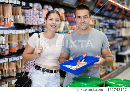Couple bought brushes and tray pallet expendable materials in paint department of construction store Couple bought brushes and tray pallet expendable materials in paint department of construction store 133742152
