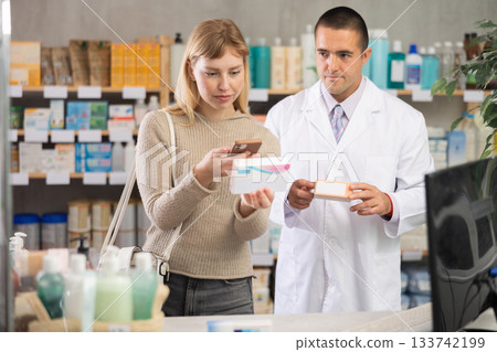 woman scans the barcode of a package with pills on her phone against the background of pharmacist woman scans the barcode of a package with pills on her phone against the background of pharmacist 133742199