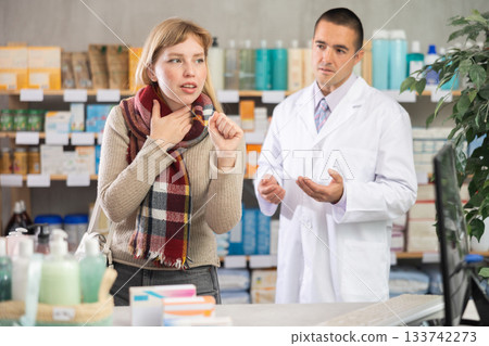 Woman with cold throat in front of pharmacist 133742273