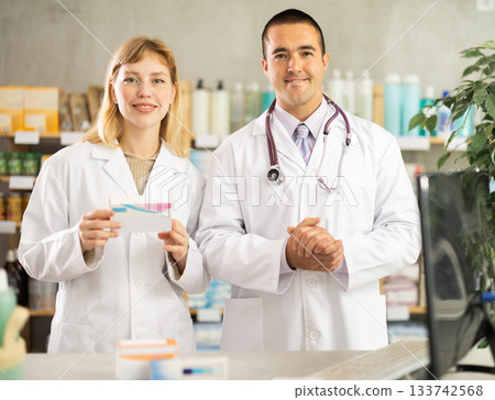 Young pharmacists inviting clients in chemist's shop 133742568