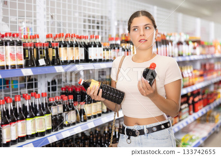 Young woman choosing soy sauce in store 133742655