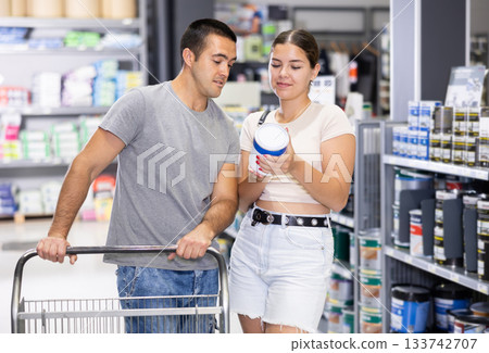 Smiling couple talking while choosing paints in construction hypermarket 133742707