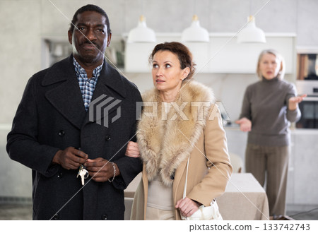 Middle-aged couple leaving the house while old woman quarreling to them 133742743
