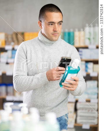Young man scanning qr code of mouthwash 133742814