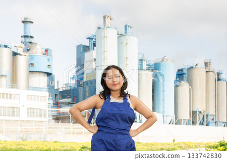 Portrait of girl in construction protective overalls against the backdrop of modern metallurgical or chemical plant Portrait of girl in construction protective overalls against the backdrop of modern metallurgical or chemical plant 133742830