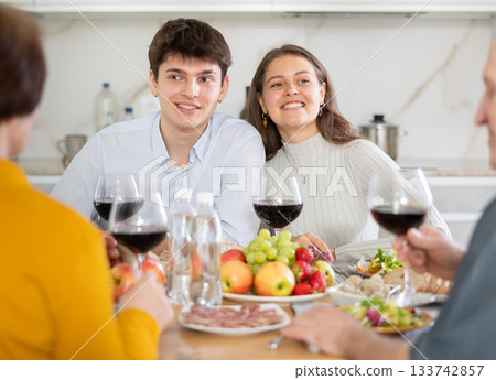 Happy family having dinner together at festive table at home 133742857