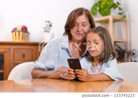 Grandmother and granddaughter using smartphone 133743223