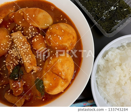 Spicy Korean tteokbokki with chewy rice cakes in a vibrant red sauce, topped with sesame seeds and green onions. A popular street food known for its addictive flavor and satisfying texture. Spicy Korean tteokbokki with chewy rice cakes in a vibrant red sauce, topped with sesame seeds and green onions. A popular street food known for its addictive flavor and satisfying texture. 133743284