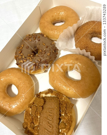 Delicious doughnuts with a golden, fluffy texture, topped with colorful glazes and sprinkles. Perfect for dessert or breakfast photography, showcasing the sweet indulgence of these classic treats. 133743289