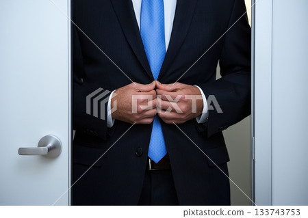 A man in a suit is getting ready to leave the room A man in a suit is getting ready to leave the room 133743753