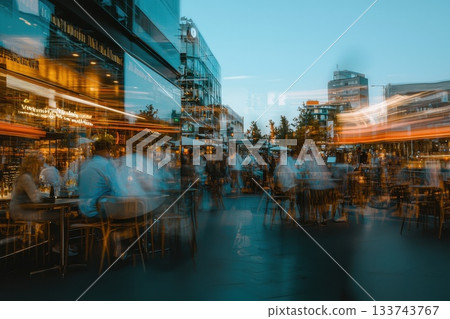 A busy city street with people sitting at tables A busy city street with people sitting at tables 133743767