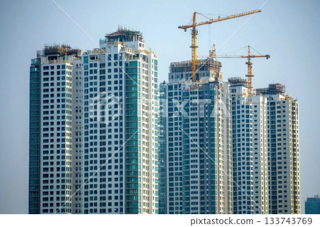 A tall building with a crane in the background A tall building with a crane in the background 133743769
