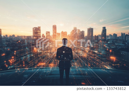 Business Person Watching City Skyline at Sunset with Digital Effects 133743812
