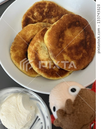 Golden, crispy Hotteok, a popular Korean street snack filled with gooey, sweet syrup, brown sugar, and nuts. Perfectly warm and satisfying with each chewy bite. 133743828