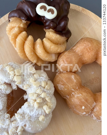 Delicious doughnuts with a golden, fluffy texture, topped with colorful glazes and sprinkles. Perfect for dessert or breakfast photography, showcasing the sweet indulgence of these classic treats. Delicious doughnuts with a golden, fluffy texture, topped with colorful glazes and sprinkles. Perfect for dessert or breakfast photography, showcasing the sweet indulgence of these classic treats. 133744120