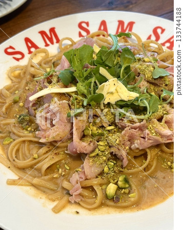 Creamy and rich spaghetti coated in a luscious white sauce, offering a smooth and savory flavor perfect for a comforting and satisfying meal. 133744188