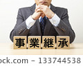 一塊寫著「企業傳承」字樣的磚塊，以及一位商人 133744538