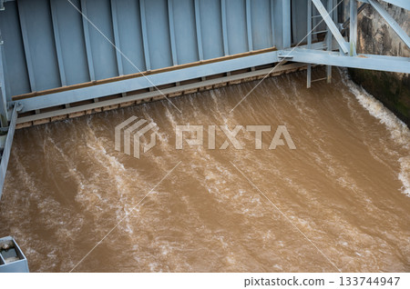 Spillway of Chiang Rai dam open for release water. Spillway, passage for surplus water over or around a dam when the reservoir itself is full. 133744947