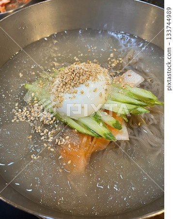 Authentic Pyongyang naengmyeon with chewy buckwheat noodles in cold, clear broth, offering a refreshing and delicate flavor. Perfect for traditional Korean cuisine menus and summer dishes. 133744989