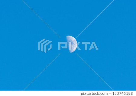A white half moon floats in the blue sky on a summer evening 04 A white half moon floats in the blue sky on a summer evening 04 133745198