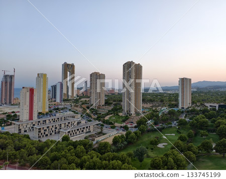 city skyline overview, aerial perspective of modern city with green spaces and ongoing construction city skyline overview, aerial perspective of modern city with green spaces and ongoing construction 133745199