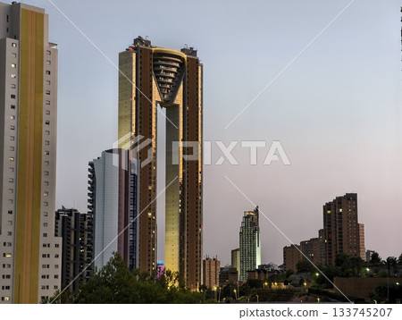 modern gold tower reflects pastel sky, architect examines illuminated skyscraper before evening modern gold tower reflects pastel sky, architect examines illuminated skyscraper before evening 133745207