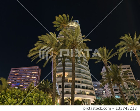 night hotel amidst greenery, nighttime hotel with glowing facade amidst verdant palms and greenery night hotel amidst greenery, nighttime hotel with glowing facade amidst verdant palms and greenery 133745218