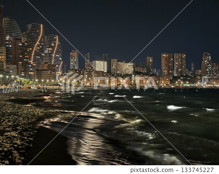 curved skyline by moonlit shore with shimmering water urban architecture and quiet coastal 133745227