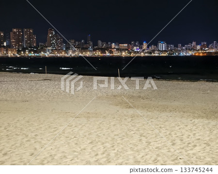 calm night by empty shoreline, tranquil coastal landscape illuminated by soft nocturnal lighting 133745244