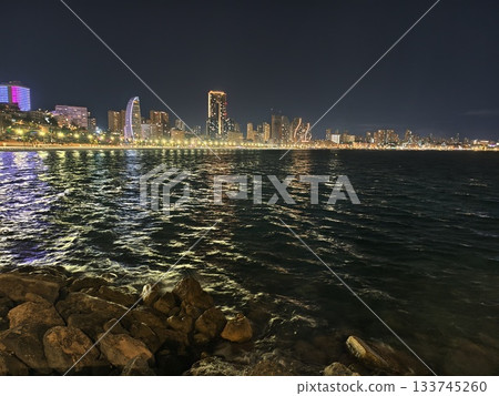 vivid skyline reflection, colorful city skyline reflected on rocky foreground with rippling water vivid skyline reflection, colorful city skyline reflected on rocky foreground with rippling water 133745260