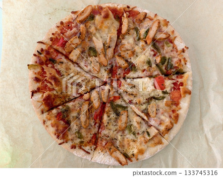 freshly baked rustic pizza on parchment paper, delicious warm rustic pizza slices served 133745316