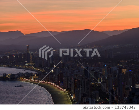 vibrant coastal scene, bright evening lights along serpentine seaside walkway with reflections vibrant coastal scene, bright evening lights along serpentine seaside walkway with reflections 133745342