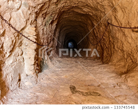 abandoned rusty mine shaft, weathered underground mine with rusted chains and uneven rocky terrain abandoned rusty mine shaft, weathered underground mine with rusted chains and uneven rocky terrain 133745548