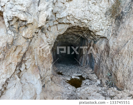sunlit rocky cave entrance exudes desert ambiance, bright desert vibe at sunlit rocky shelter 133745551