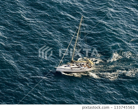 sailboat on ocean, sailboat drifting peacefully over vibrant turquoise sea with bright sun sailboat on ocean, sailboat drifting peacefully over vibrant turquoise sea with bright sun 133745563