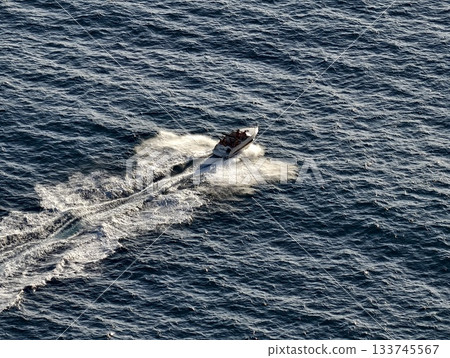 highenergy coastal chase with speedboat, dynamic speedboat racing across open water under bright sky highenergy coastal chase with speedboat, dynamic speedboat racing across open water under bright sky 133745567