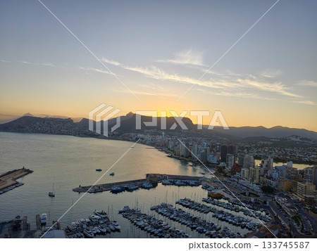 evening sunset casts golden light on peaceful marina with reflective waters and calm atmosphere 133745587