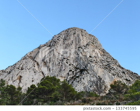 serene mountain with lush greenery, tranquil mountain summit surrounded by green pines and blue sky 133745595