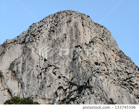 mountain face featuring cracks and shadows, rugged rock surface with visible fissures and shadows mountain face featuring cracks and shadows, rugged rock surface with visible fissures and shadows 133745596