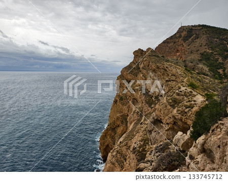 rugged cliffs meet turquoise waters, vast rocky cliff over vibrant turquoise ocean with erosion rugged cliffs meet turquoise waters, vast rocky cliff over vibrant turquoise ocean with erosion 133745712