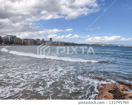 urban coastal waves, surf crashes on rocky shore, chaotic waves meet rugged rocks at city coast 133745760