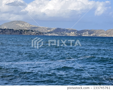 tranquil sea horizon, peaceful azure ocean with gentle waves overlooking small coastal town on sunny tranquil sea horizon, peaceful azure ocean with gentle waves overlooking small coastal town on sunny 133745761