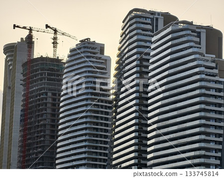modern skyline development, wavy residential skyscrapers under construction with vibrant sunset modern skyline development, wavy residential skyscrapers under construction with vibrant sunset 133745814